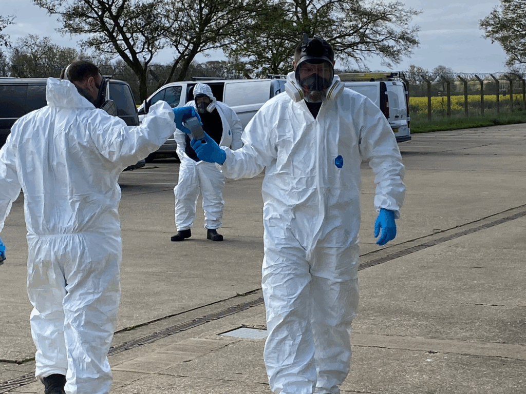 IMG_2851 copy linkedin copy Two oil spill cleanup professionals in protective suits shaking hands after successful operation